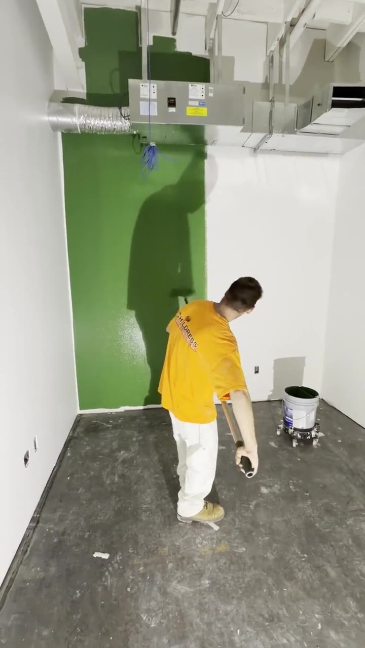 A Childress Painting crew member rolling an accent wall on a commercial interior